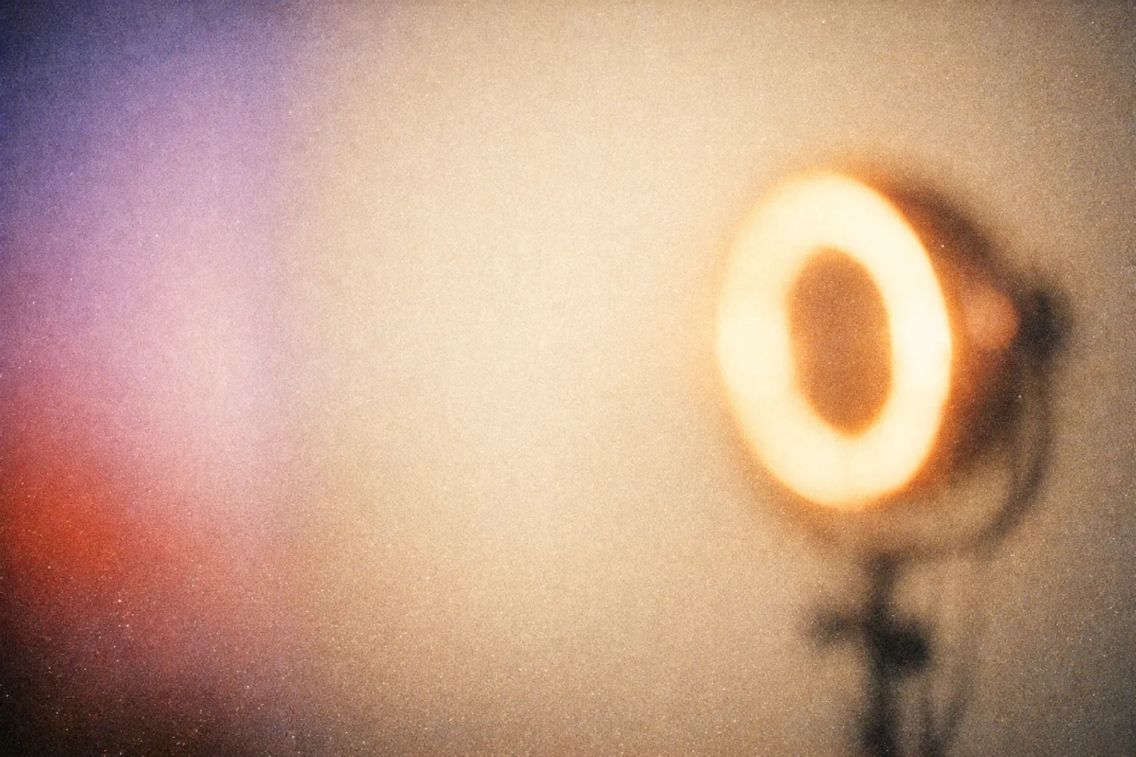 Unscharfes warmes Ringlicht auf cremefarbenem Studiohintergrund